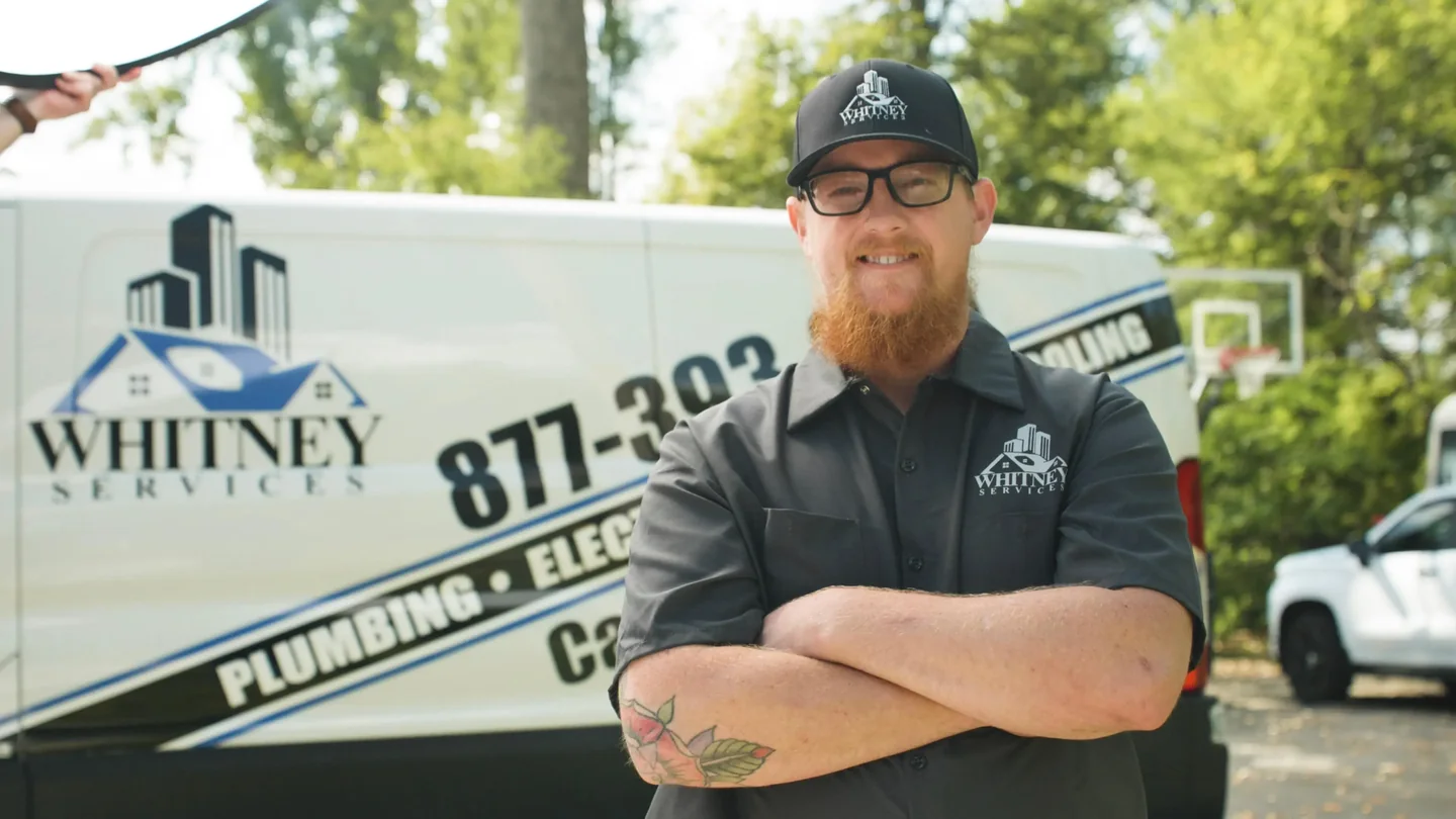 Whitney Services team member in front of a company vehicle